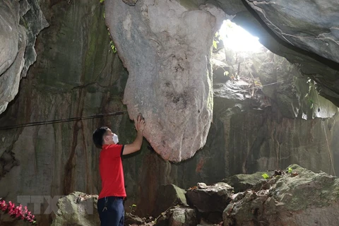 Chiếc chuông bằng đá lớn ở động Đền Trung chùa Hang São, khi gõ vào âm vang như trống đồng. (Ảnh: Việt Dũng/TTXVN) 