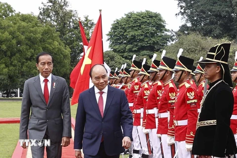 Chủ tịch nước Nguyễn Xuân Phúc và Tổng thống nước Cộng hòa Indonesia Joko Widodo duyệt đội danh dự. (Ảnh: Thống Nhất/TTXVN)