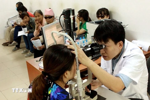 Bác sỹ khám và điều trị cho người đau mắt đỏ tại Bệnh viện Mắt Trung ương. (Ảnh: TTXVN/Vietnam+)
