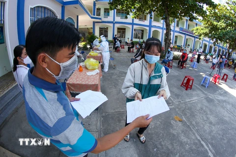 Phát tờ khai thông tin y tế cho người dân Phú Yên đến lấy mẫu xét nghiệm COVID-19. (Ảnh: Trần Lê Lâm/TTXVN)