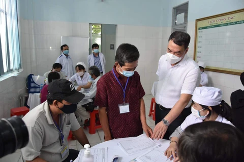 Lãnh đạo Bộ Y tế kiểm tra thủ tục trước khi tiến hành tiêm thử nghiệm. (Ảnh: PV/Vietnam+)