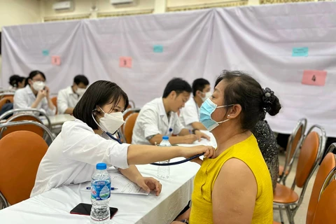 Nhân viên y tế khám sàng lọc bệnh cho người dân. (Ảnh: PV/Vietnam+)
