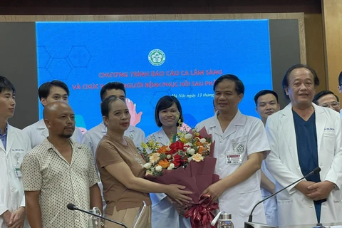 Gia đình Hà Thị B. tặng hoa cảm ơn các y bác sỹ Bệnh viện Bạch Mai. (Ảnh: PV/Vietnam+)