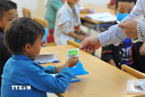 Nhân viên y tế cấp phát thuốc uống phòng dịch bạch hầu cho học sinh Trường Phổ thông dân tộc bán trú tiểu học xã Khâu Vai. (Ảnh: Hoàng Hiếu/TTXVN)