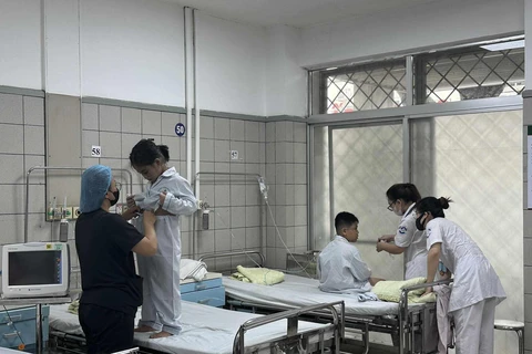 Nhân viên y tế chăm sóc cho bệnh nhi điều trị tại Bệnh viện Bạch Mai. (Ảnh: PV/Vietnam+)