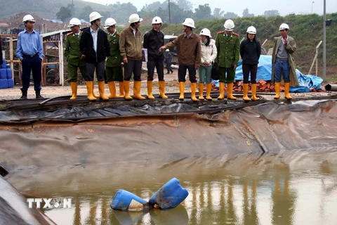 Cán bộ và công an môi trường tỉnh Quảng Nam kiểm tra hồ chứa nước thải của Nhà máy vàng Bồng Miêu. (Ảnh: Trần Tĩnh/TTXVN)