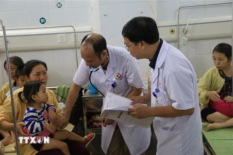 Các y tá, bác sỹ đang nỗ lực dồn sức cứu chữa bệnh cho trẻ tại Bệnh viện đa khoa Đông Anh. (Ảnh: Nguyễn Thắng/TTXVN)