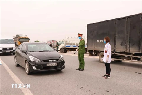 Các lực lượng chức năng dừng xe kiểm soát dịch bệnh tại điểm chốt cầu Như Nguyệt, thành phố Bắc Ninh, tỉnh Bắc Ninh trên cao tốc Hà Nội-Bắc Giang. (Ảnh: Thanh Thương/TTXVN)