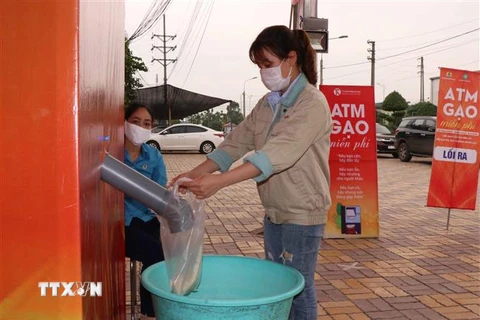 Công nhân lấy gạo miễn phí tại cây ATM gạo tại Khu công nghiệp Quế Võ, tỉnh Bắc Ninh. (Ảnh: Thái Hùng/TTXVN)