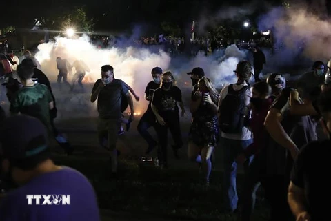 Người biểu tình xung đột với cảnh sát trong cuộc tuần hành phản đối vụ cảnh sát bắn người da màu tại Kenosha, bang Wisconsin (Mỹ). (Ảnh: AFP/TTXVN)