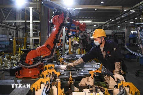 Công nhân làm việc bên trong một nhà máy ở Du Bắc, tỉnh Trùng Khánh, Trung Quốc. (Ảnh: THX/TTXVN)