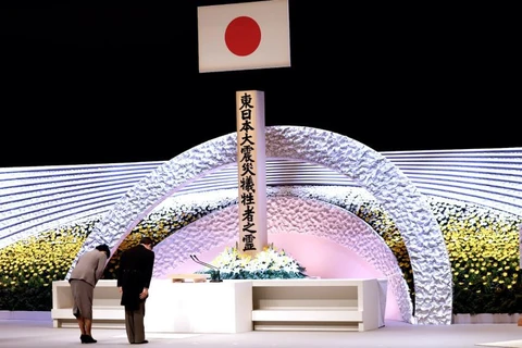 Nhật hoàng Naruhito và Hoàng hậu Masako cúi đầu tưởng niệm các nạn nhân của thảm họa kép (Nguồn: AP)