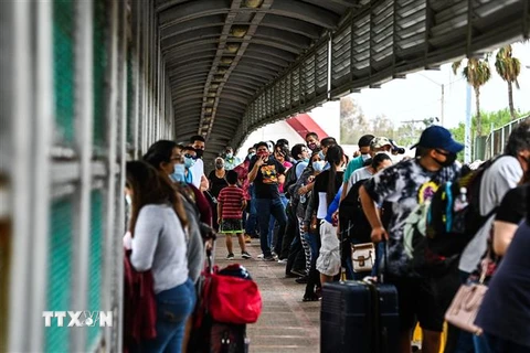 Người di cư Trung Mỹ xếp hàng chờ di chuyển qua cầu quốc tế Gateway từ Matamoros (Mexico) tới Texas (Mỹ). (Ảnh: AFP/TTXVN)