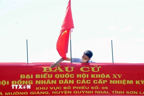 Lắp đặt Panô tuyên truyền tại khu vực bỏ phiếu số 5, xã Mường Giàng, huyện Quỳnh Nhai. (Ảnh: Quang Quyết/TTXVN)