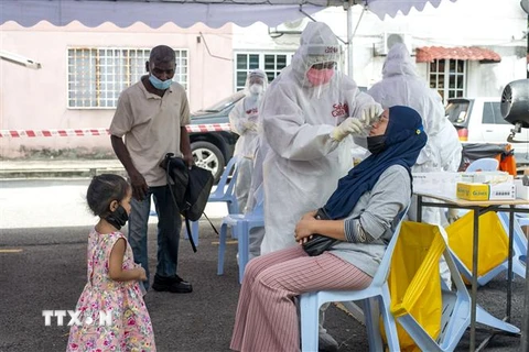 Nhân viên y tế lấy mẫu xét nghiệm COVID-19 cho người dân tại Selangor, Malaysia. (Ảnh: THX/TTXVN) 
