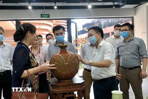 Lãnh đạo Bộ Công Thương và Sở Công Thương thành phố Hà Nội đến thăm làng nghề Bát Tràng. (Ảnh: TTXVN)