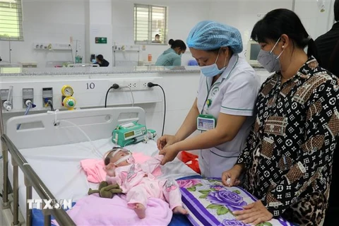 Bác sỹ Bệnh viện Sản-Nhi Kiên Giang khám, điều trị cho trẻ sốt xuất huyết. (Ảnh: Lê Huy Hải/TTXVN)