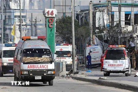 Nhân viên an ninh và xe cứu thương được triển khai tại hiện trường vụ nổ bom nhằm vào trụ sở Bộ Giáo dục Somalia ở thủ đô Mogadishu. (Ảnh: AFP/TTXVN)