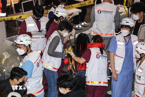 Nhân viên y tế hỗ trợ nạn nhân tại hiện trường vụ giẫm đạp trong lễ Halloween ở Itaewon, Seoul, Hàn Quốc. (Ảnh: YONHAP/TTXVN)