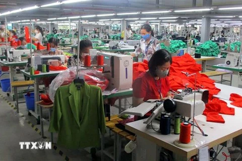 Công nhân Nhà máy may xuất khẩu Sơn Hà (thị xã Bỉm Sơn) bị giảm thu nhập do công ty thiếu đơn hàng. (Ảnh: Nguyễn Nam/TTXVN)