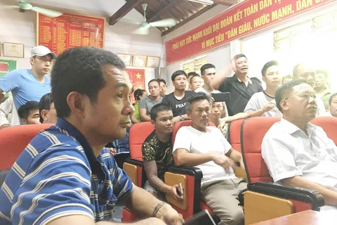 Ông Nguyễn Phước Quy Phong, Phó Tổng Giám đốc công ty CP vận tải và thương mại Quốc tế - chủ tàu hàng Pacific 01 (áo kẻ xanh) đối thoại với người thân các nạn nhân. (Ảnh: TTXVN phát)