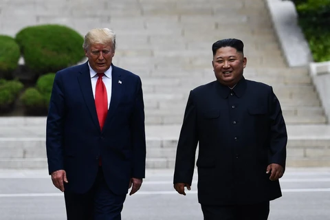 Tổng thống Mỹ Donald Trump (trái) và nhà lãnh đạo Triều Tiên Kim Jong-un trong cuộc gặp tại Khu Phi quân sự (DMZ) ở biên giới liên Triều ngày 30/6 vừa qua. (Ảnh: AFP/TTXVN)