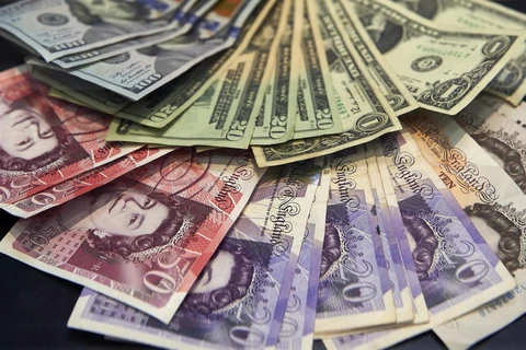 Đồng bảng Anh và đồng USD. (Ảnh: AFP/TTXVN)