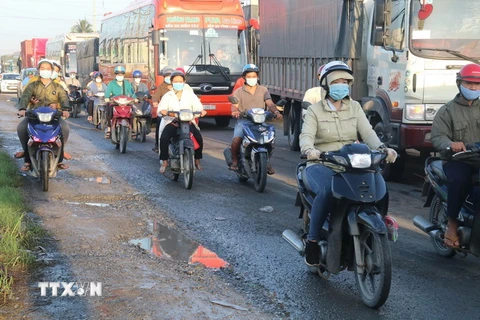 Người dân ở Tiền Giang thực hiện nghiêm túc đeo khẩu trang khi ra đường. (Ảnh: Minh Trí/TTXVN)