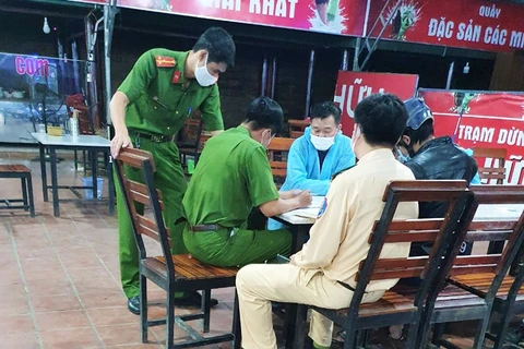 Cơ quan chức năng huyện Đạ Huoai và chốt số 1 làm việc với ông Trần Quang Vinh, người mặc đồ bảo hộ y tế. (Nguồn: thethaovanhoa)