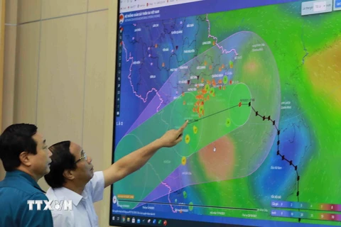 Phó Thủ tướng Lê Văn Thành xem sơ đồ đường đi của bão số 7. (Ảnh: Vũ Sinh/TTXVN)