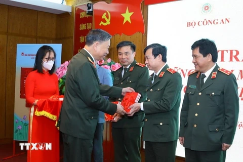 Bộ trưởng Bộ Công an Tô Lâm tặng sách cho các đại biểu. (Ảnh: Văn Điệp/TTXVN)