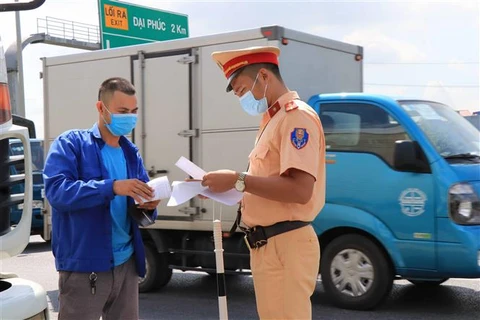 Lực lượng Cảnh sát Giao thông nhắc nhở chủ phương tiện về các biện pháp bảo đảm trật tự an toàn giao thông. (Ảnh: Thanh Thương/TTXVN)