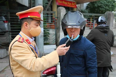 Lực lượng Cảnh sát giao thông kiểm tra nồng độ cồn của người tham gia giao thông. (Ảnh: Phạm Kiên/TTXVN)