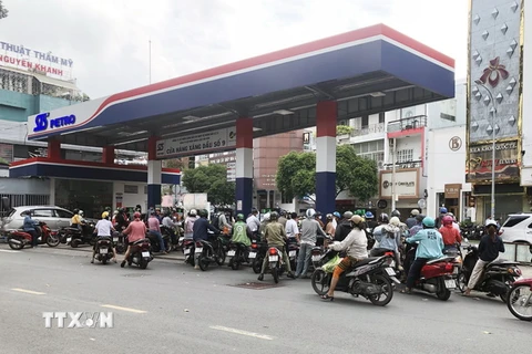 Nhiều cửa hàng kinh doanh xăng, dầu tại Thành phố Hồ Chí Minh có lượng khách hàng tập trung đông và tràn ra cả lòng lề đường. (Ảnh: Mỹ Phương/TTXVN)