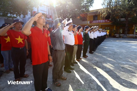 Dưới lá quốc kỳ, toàn bộ cán bộ, chiến sỹ trên đảo hát vang Quốc ca và đọc 10 lời thề của quân nhân Quân đội nhân dân Việt Nam. (Ảnh: PV/Vietnam+)