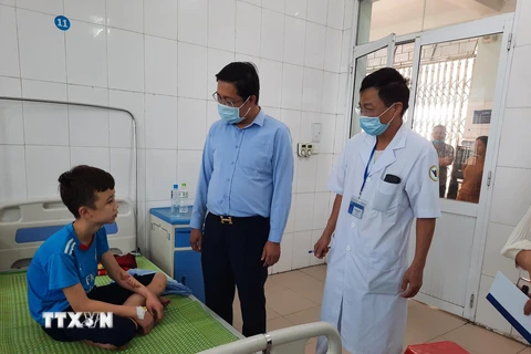 Lãnh đạo Sở Lao động-Thương binh và Xã hội tỉnh Bắc Ninh thăm hỏi, động viên cháu Trương Quang Duy tại Trung tâm Y tế huyện Yên Phong, tỉnh Bắc Ninh. (Ảnh: Thanh Thương/TTXVN)