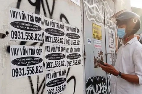Các tờ rơi, biển quảng cáo cho vay xuất hiện “nhan nhản” trên bờ tường, trụ điện trong các khu công nghiệp. (Ảnh minh họa: TTXVN)