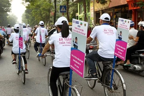 Các em học sinh tham gia đạp xe, phát tờ rơi với thông điệp thành phố an toàn cho trẻ em gái. (Nguồn: Plan International Việt Nam)