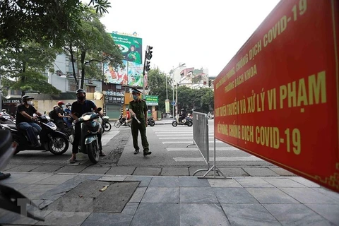 Công an phường Bách Khoa kiểm tra người tham gia giao thông tại chốt phòng, chống dịch trên tuyến phố Lê Thanh Nghị. (Ảnh: TTXVN)