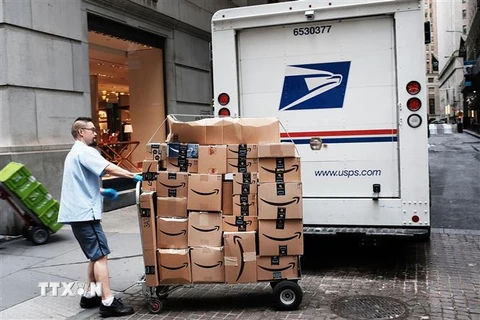 Nhân viên Công ty Dịch vụ bưu chính Mỹ (USPS) chuyển bưu kiện tại New York, Mỹ. (Nguồn: AFP/TTXVN) 