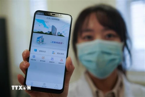 Nhân viên y tế bệnh viện ở Nam Kinh, tỉnh Giang Tô (Trung Quốc) giới thiệu trang mạng tư vấn trực tuyến sơ bộ về virus corona chủng mới (COVID-19) hỗ trợ người dân phòng ngừa và ngăn chặn khả năng lây lan của dịch bệnh, ngày 7/2/2020. (Nguồn: THX/TTXVN) 