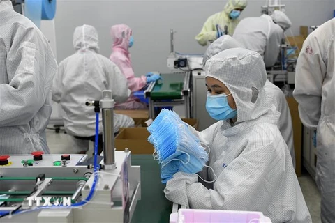 Công nhân làm việc tại xưởng sản xuất khẩu trang ở Quảng Đông, Trung Quốc, ngày 17/3/2020. (Nguồn: THX/TTXVN) 