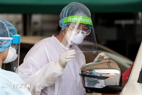 Nhân viên y tế lấy mẫu xét nghiệm COVID-19 tại trạm xét nghiệm ở Bangkok, Thái Lan ngày 25/3/2020. (Nguồn: AFP/TTXVN) 