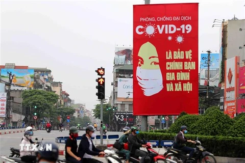 Tranh tuyên truyền về COVID-19 được đặt ở các điểm nút giao thông của Hà Nội. (Ảnh: Thanh Tùng/TTXVN) 