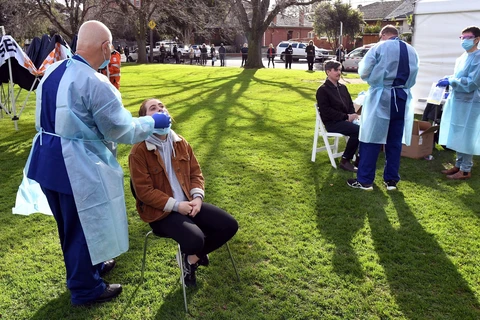 Nhân viên y tế lấy mẫu dịch xét nghiệm COVID-19 cho người dân tại thành phố Melbourne, bang Victoria, Australia ngày 2/7/2020. (Nguồn: AFP/TTXVN)
