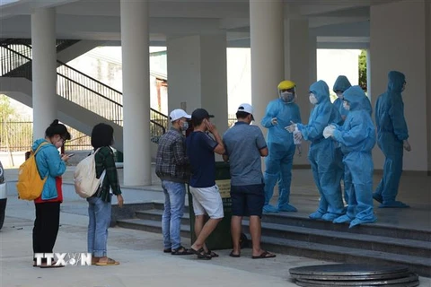 Nhân viên y tế thực hiện quy trình tiếp đón các trường hợp F1 được cách ly tại Khu ký túc xá phía Tây thành phố Đà Nẵng. (Ảnh: Văn Dũng/TTXVN)