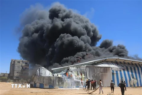 Một nhà kho bốc cháy sau vụ không kích của Israel xuống thành phố Rafah, Dải Gaza, ngày 18/5/2021. (Nguồn: THX/TTXVN) 