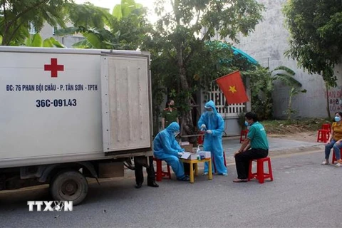 Cán bộ y tế lấy mẫu để xét nghiệm sàng lọc SARS-CoV-2 ở Thanh Hóa. (Ảnh: Nguyễn Nam/TTXVN) 