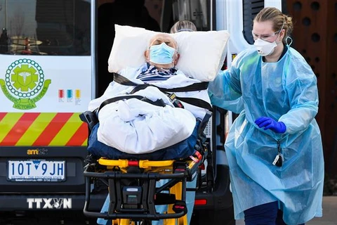 Nhân viên y tế chuyển người già khỏi nhà dưỡng lão ở Epping, Australia khi dịch COVID-19 bùng phát tại đây. (Ảnh: AFP/TTXVN) 