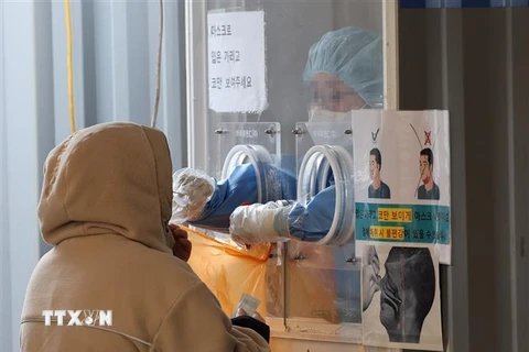 Nhân viên y tế lấy mẫu xét nghiệm COVID-19 cho người dân tại Seoul, Hàn Quốc, ngày 23/1/2022. (Ảnh: Yonhap/TTXVN) 